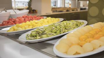 A buffet with various fruits including watermelon, pineapple, kiwi, and yellow fruit.