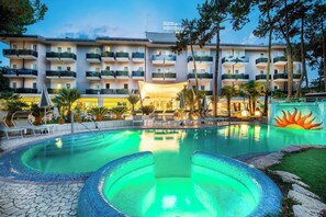 Un hôtel doté d’une piscine, d’un espace extérieur aménagé et d’un bâtiment comportant plusieurs balcons.