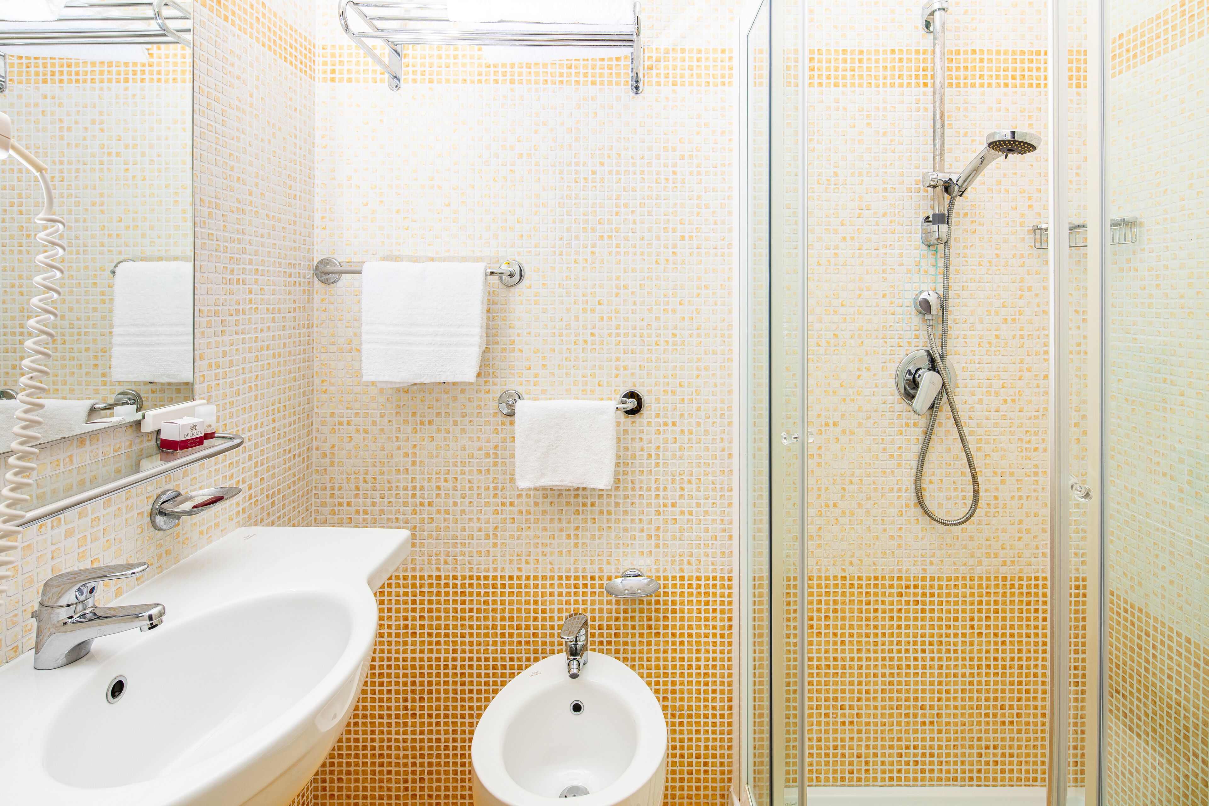 Une salle de bain équipée d’un lavabo, d’un bidet et d’une douche à parois de verre.