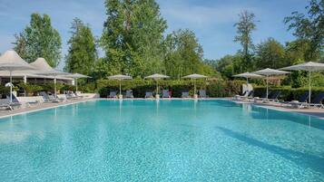 Una piscina al aire libre de temporada, sombrillas