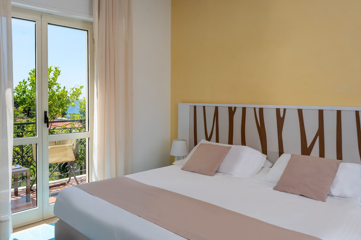 A neatly made bed with a white and beige bedspread, a wooden headboard, and two bedside lamps.