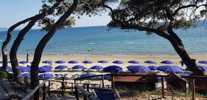 A beach with blue umbrellas and a wooden deck. - Il Pelagone Hotel & Golf Resort Toscana (Gavorrano)