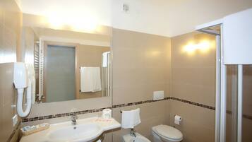 A bathroom with a sink, bidet, toilet, and a mirror.