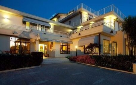A hotel with a two-story structure, a covered entrance, and a landscaped garden area.