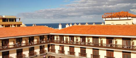 Un immeuble à plusieurs étages, doté de balcons et offrant une vue sur la mer.