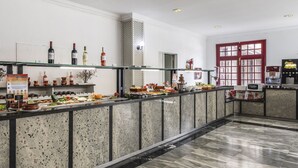 Zona de bufé con una variedad de alimentos y bebidas.