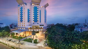 A multi-story hotel with a modern design, featuring a prominent rooftop structure and a well-lit entrance. - The Accord Metropolitan (Chennai)