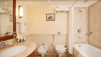 A bathroom with a sink, bidet, toilet, and bathtub.