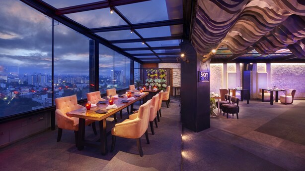 A high-rise restaurant with a panoramic city view, modern interior design, and a cozy seating area. - The Accord Metropolitan (Chennai)