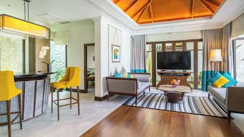 A modern living room with a wooden ceiling, a flat-screen TV, and a seating area with a sofa and armchairs.
