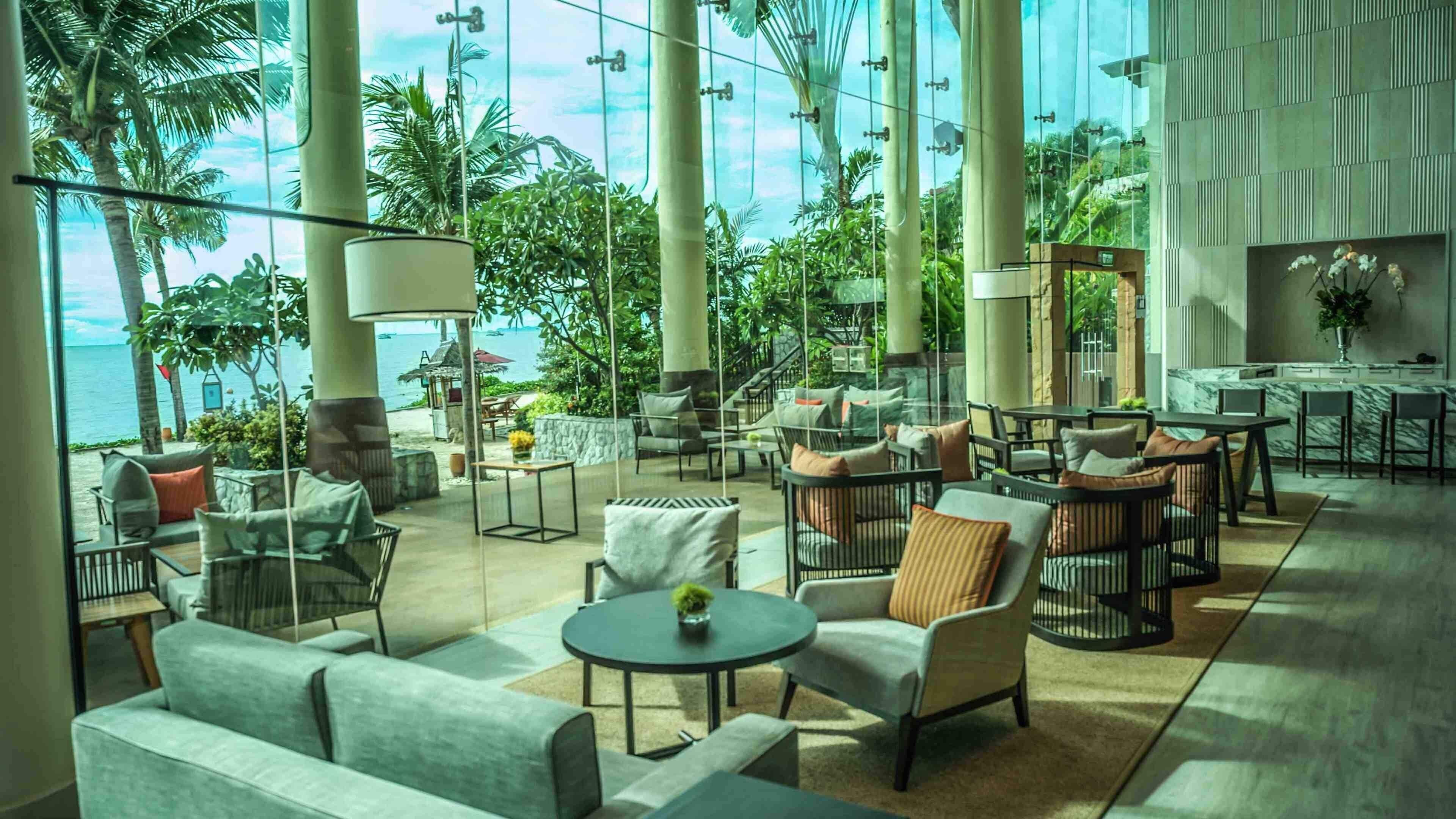 A spacious indoor area with multiple seating arrangements, a view of the ocean, and a modern architectural design.