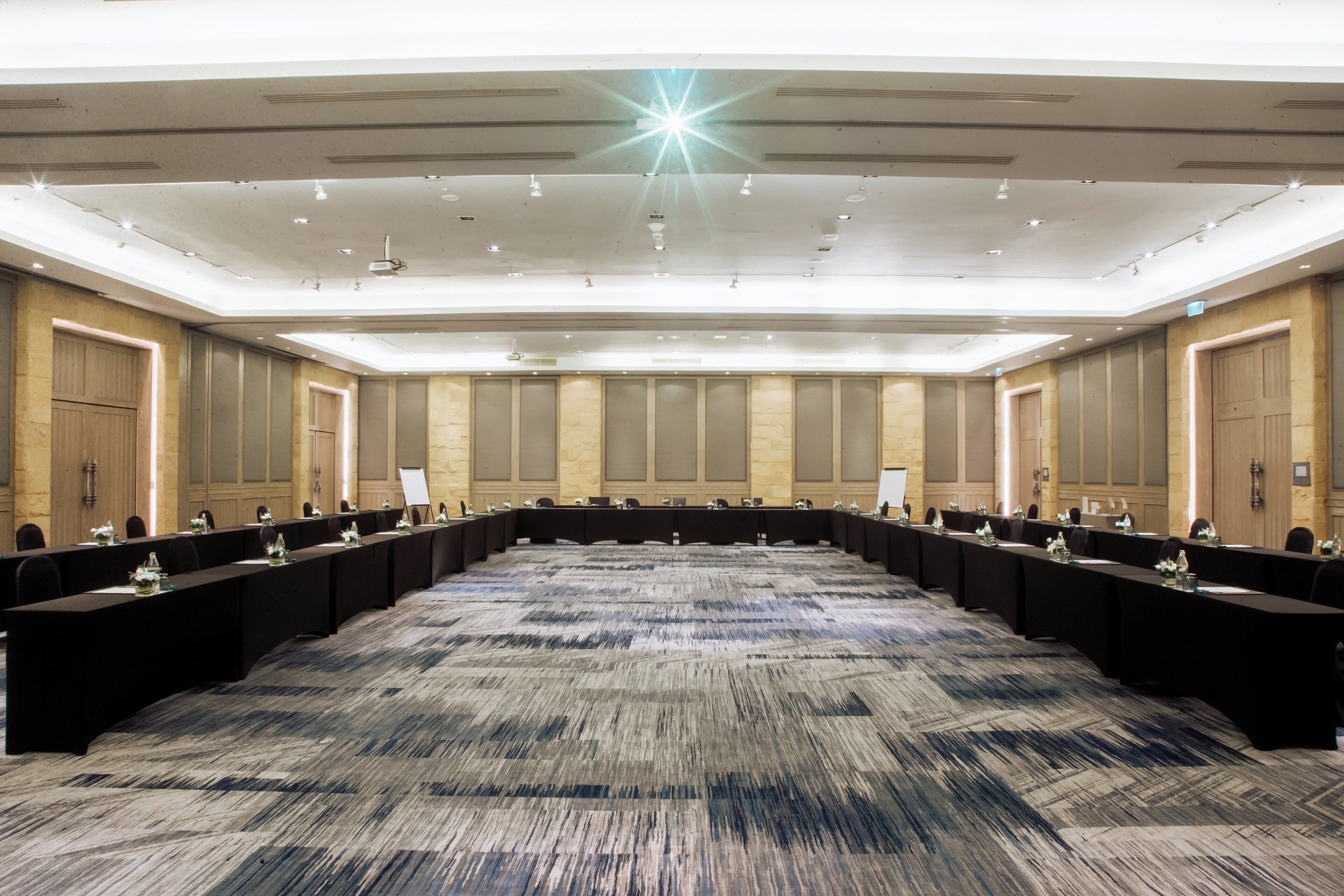A large conference room with a long table, multiple chairs, and a carpeted floor.