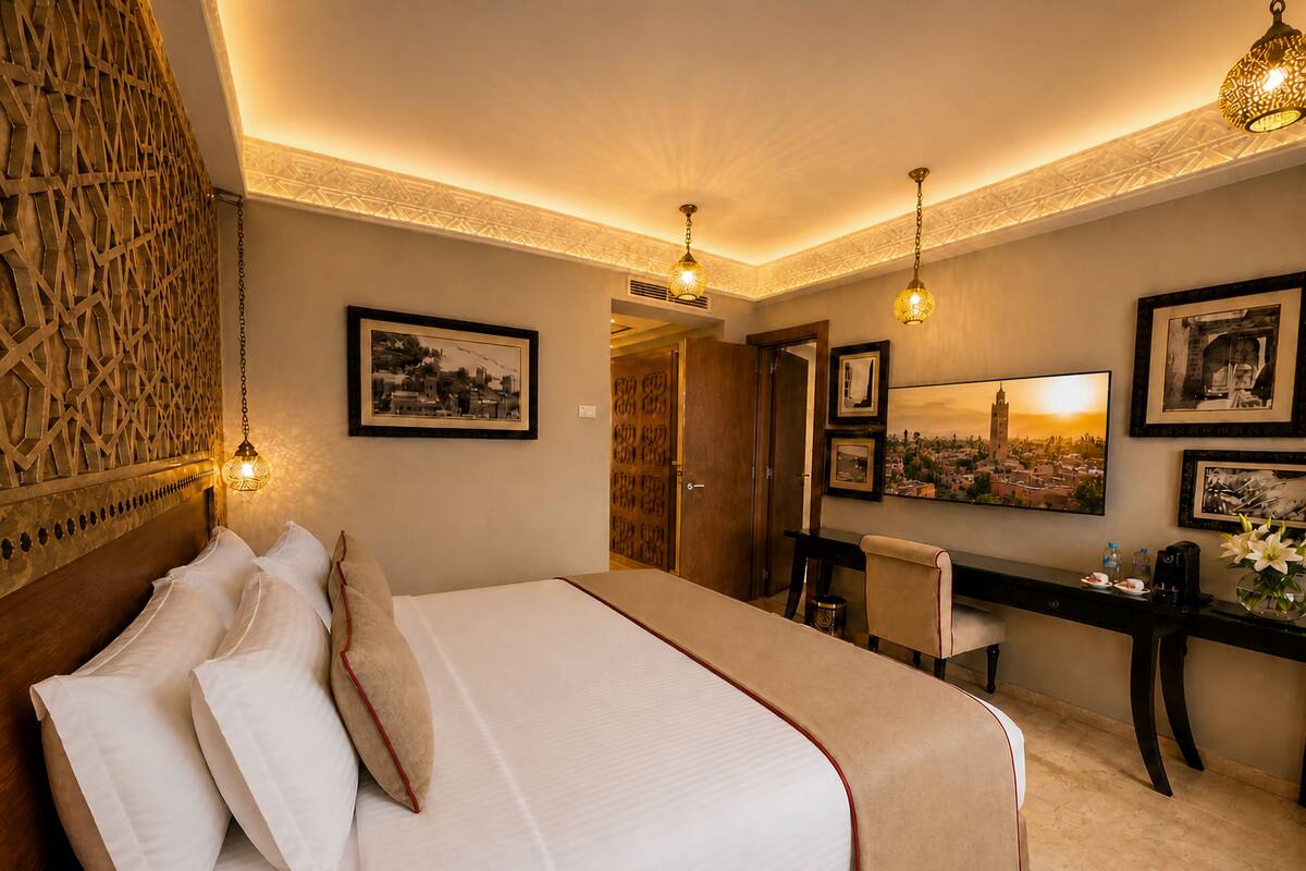 Ein Hotelzimmer mit Bett, Schreibtisch und Stühlen, einer dekorativen Wand und gerahmten Bildern.