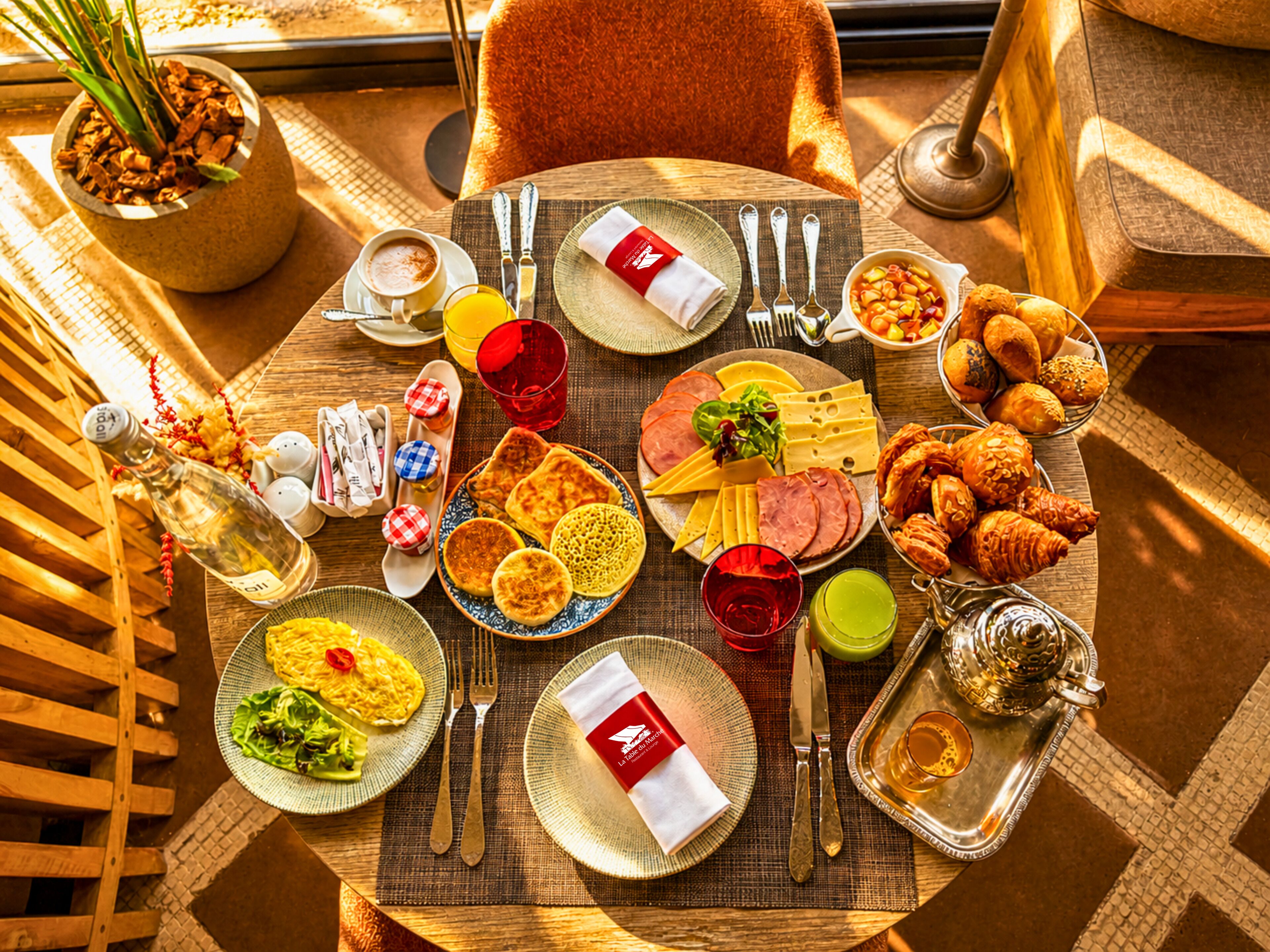 A table set with various dishes, utensils, and a bottle of wine, indicating a dining setup.