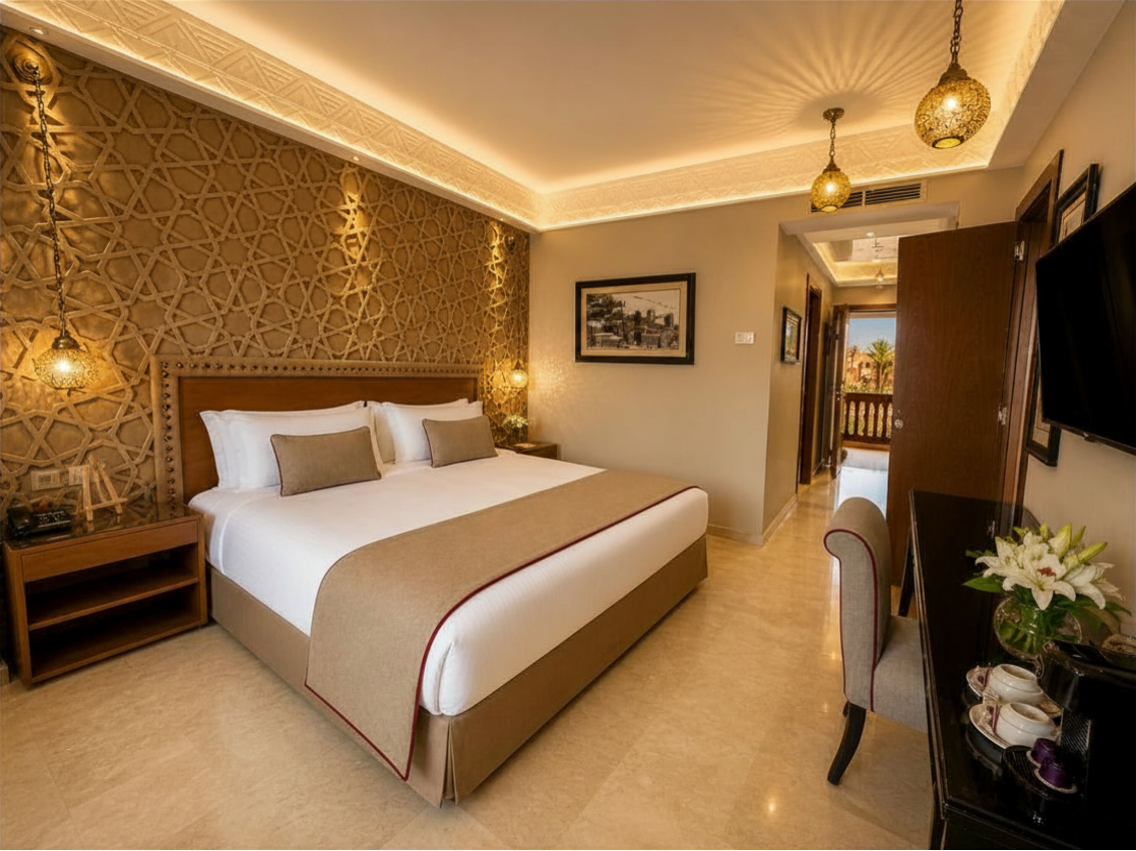 A hotel room with a large bed, a nightstand, a dresser, a television, and a decorative wall.