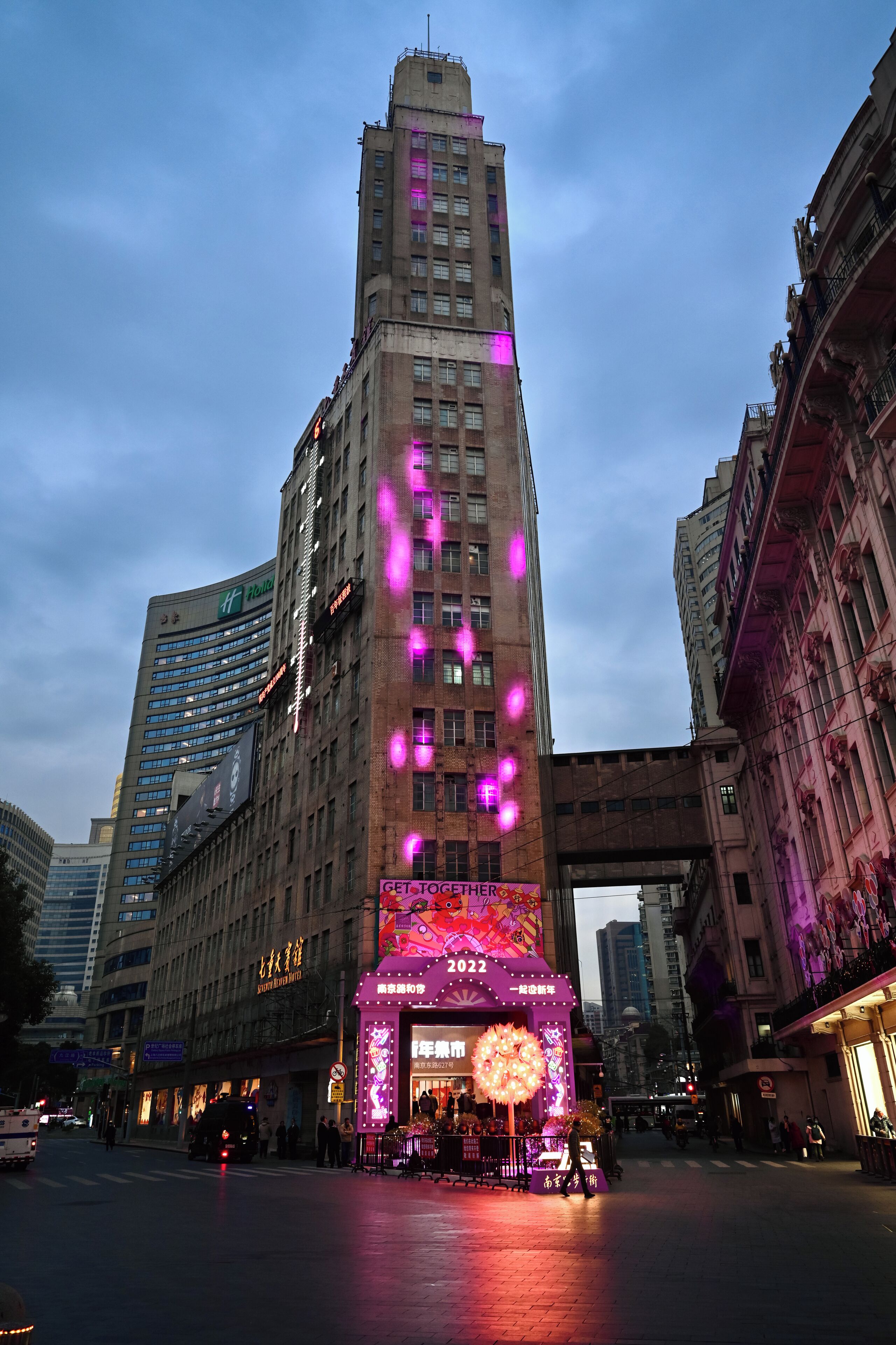 A hotel with a prominent sign and a large illuminated display at the entrance.
