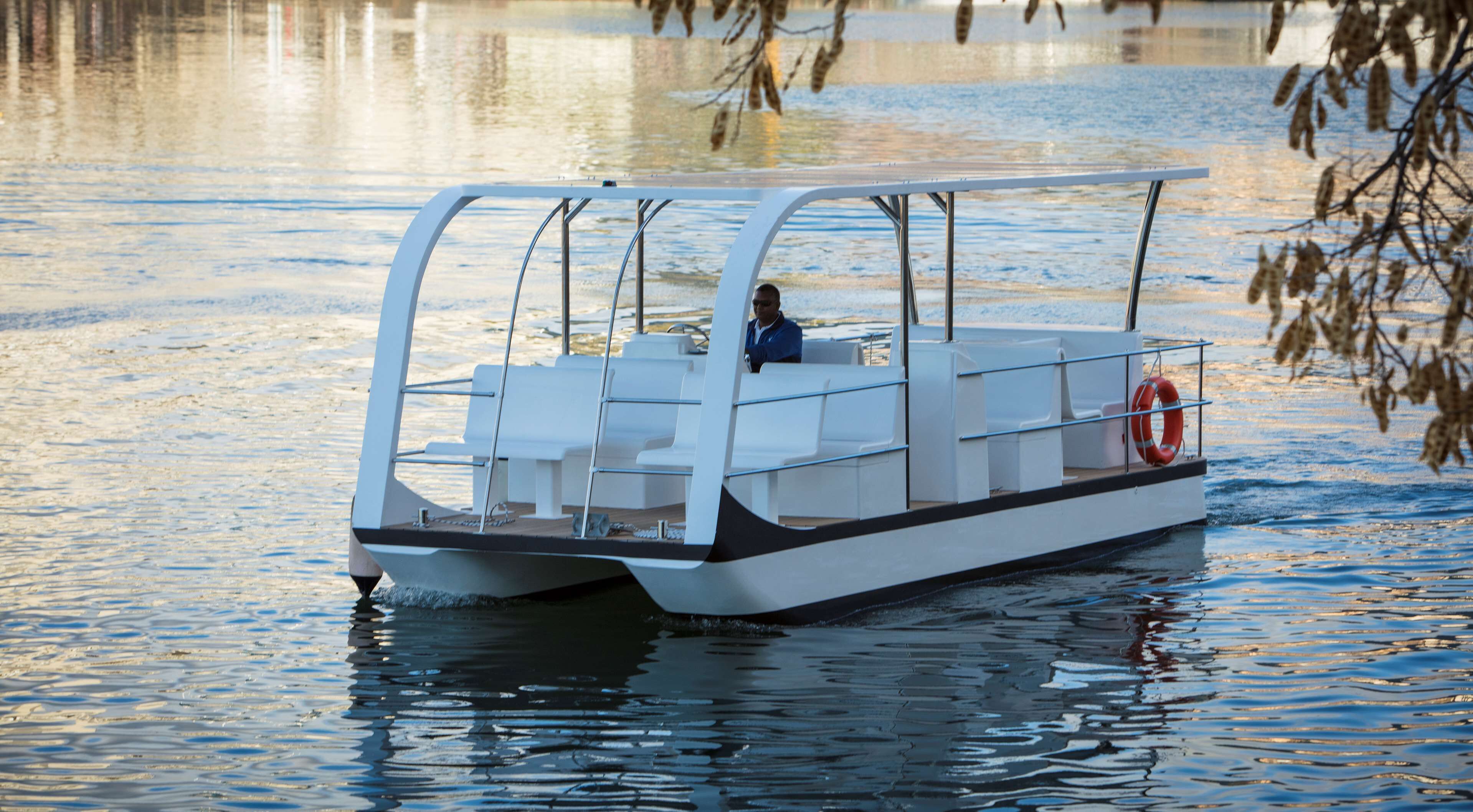 A small, modern boat with a covered seating area and a lifebuoy.