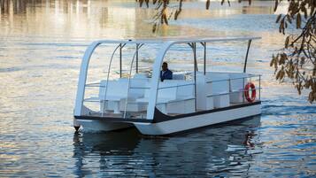 A small, modern boat with a covered seating area and a lifebuoy.