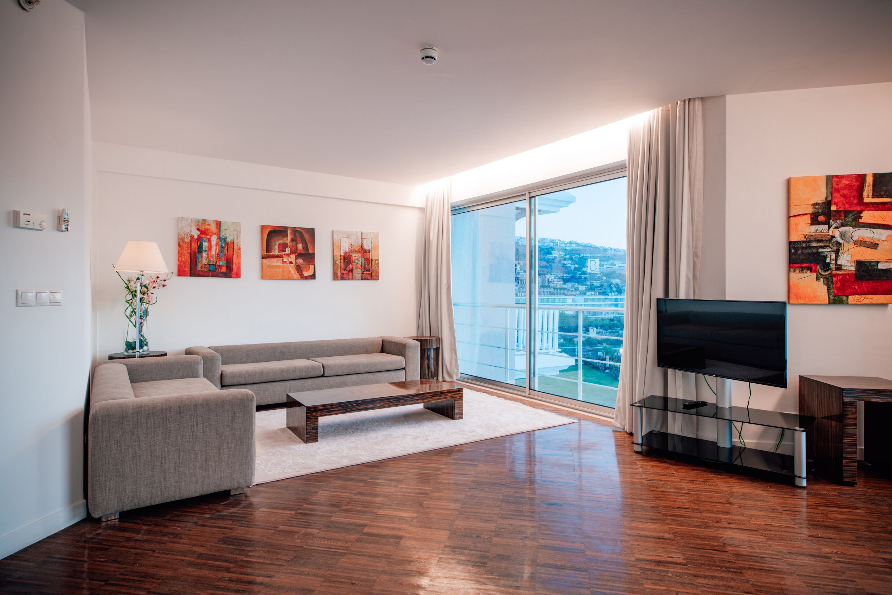 Una sala de estar moderna con un sofá, una mesa de centro y un mueble para la televisión.
