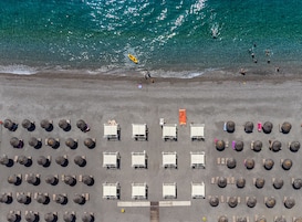 Praia particular, espreguiçadeiras, guarda-sóis, toalhas de praia 