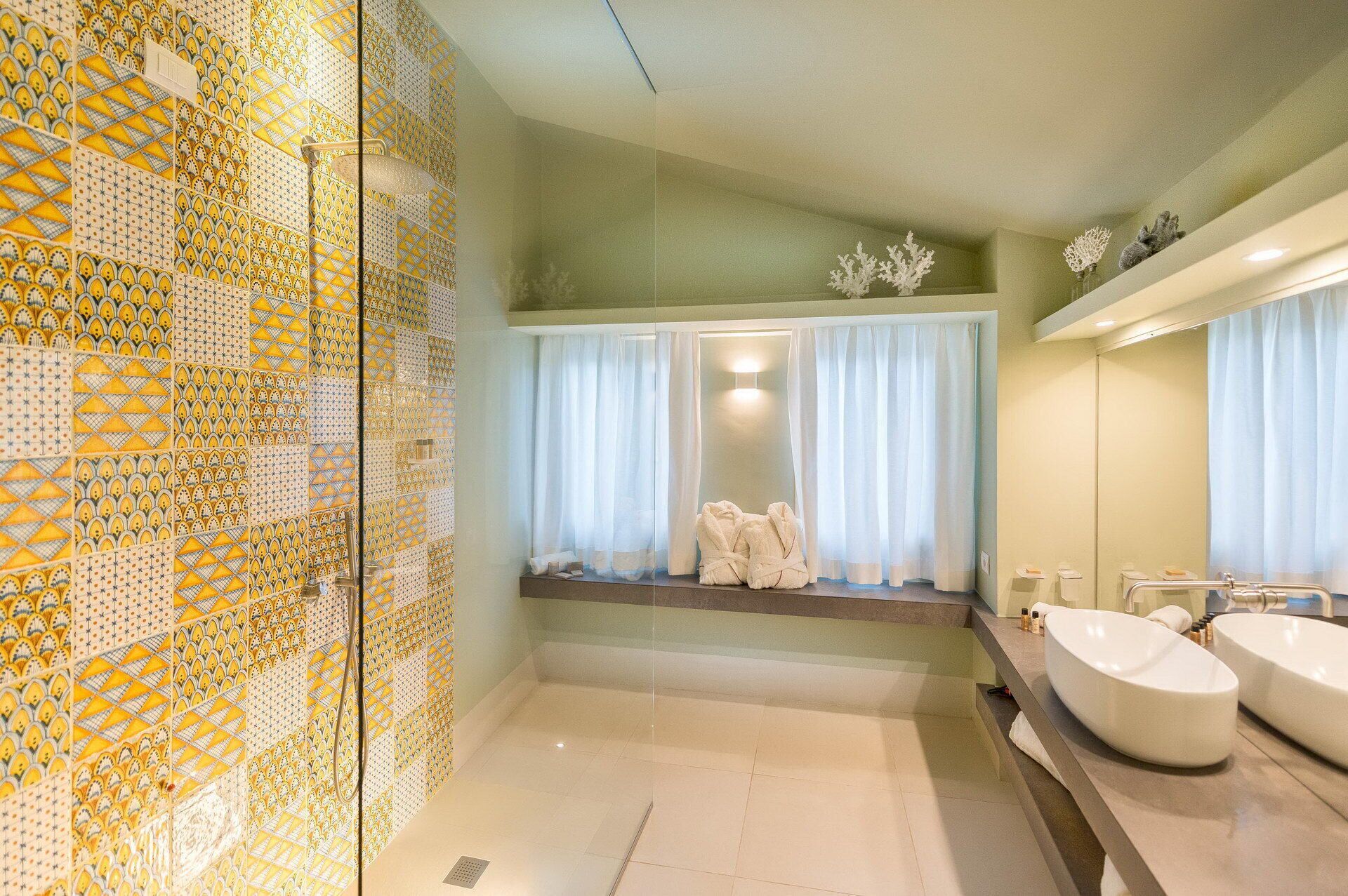 A bathroom with a tiled wall, a bathtub, a sink, and a mirror.