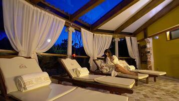 Relax in a serene outdoor lounge with sun loungers and towels under a sheltered pergola.