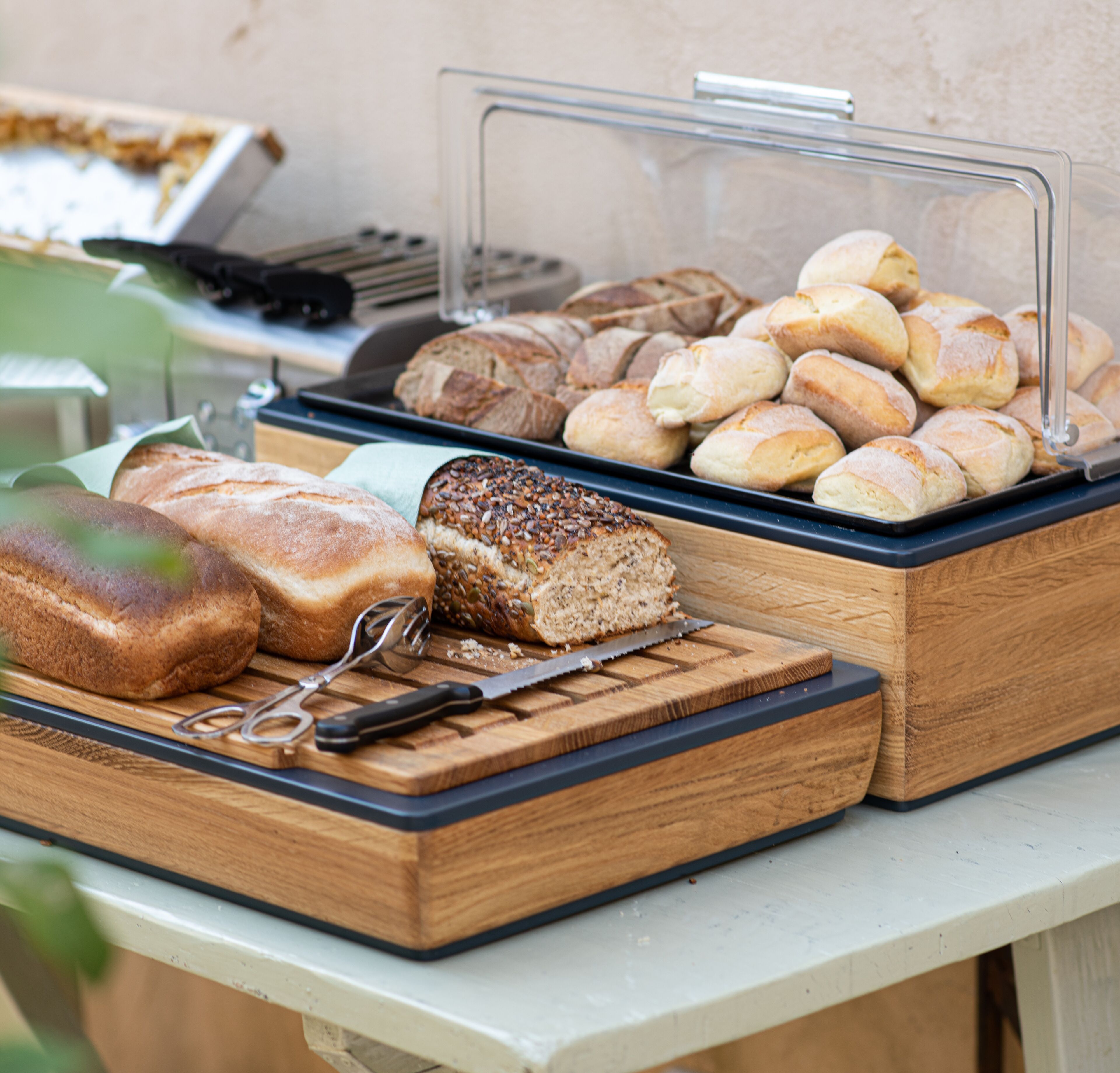 Un buffet proposant une variété de pains et de viennoiseries présentés dans des récipients transparents.