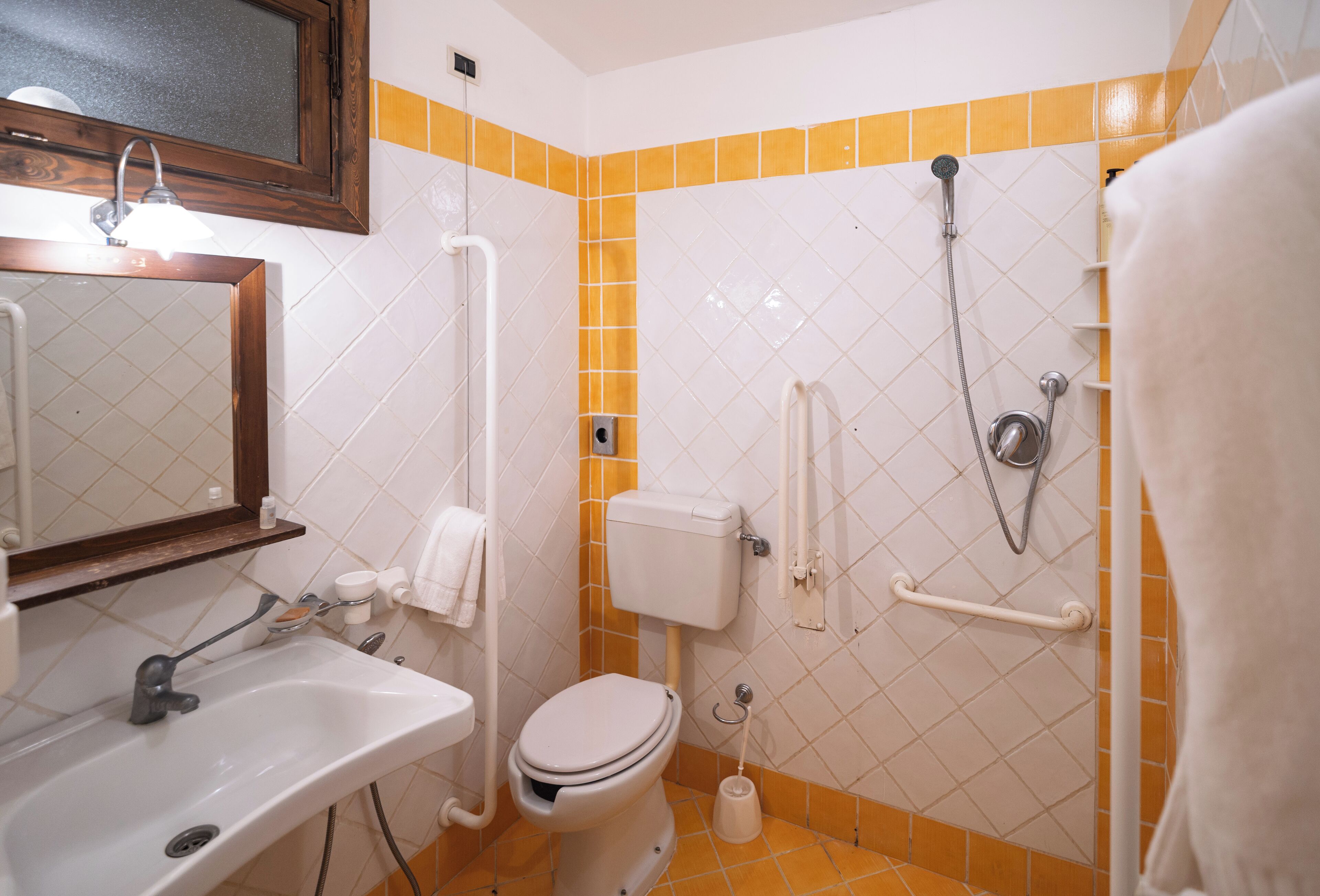 Ein Badezimmer mit weißem Waschbecken, WC und Duschbereich.