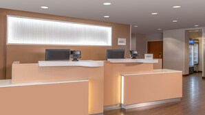 A reception area with two counters, a large window with blinds, and a sign reading "Bonvty." - Fairfield Inn and Suites by Marriott Toronto Brampton (Brampton)