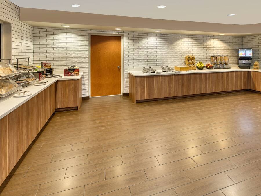 Een moderne keuken met een tegelwand, houten aanrecht en diverse soorten eten en apparatuur.