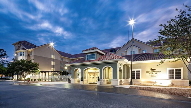 A hotel with a central building and two wings, featuring a well-lit entrance and a clear sky. - Homewood Suites by Hilton Jacksonville-South/St. Johns Ctr. (Jacksonville)