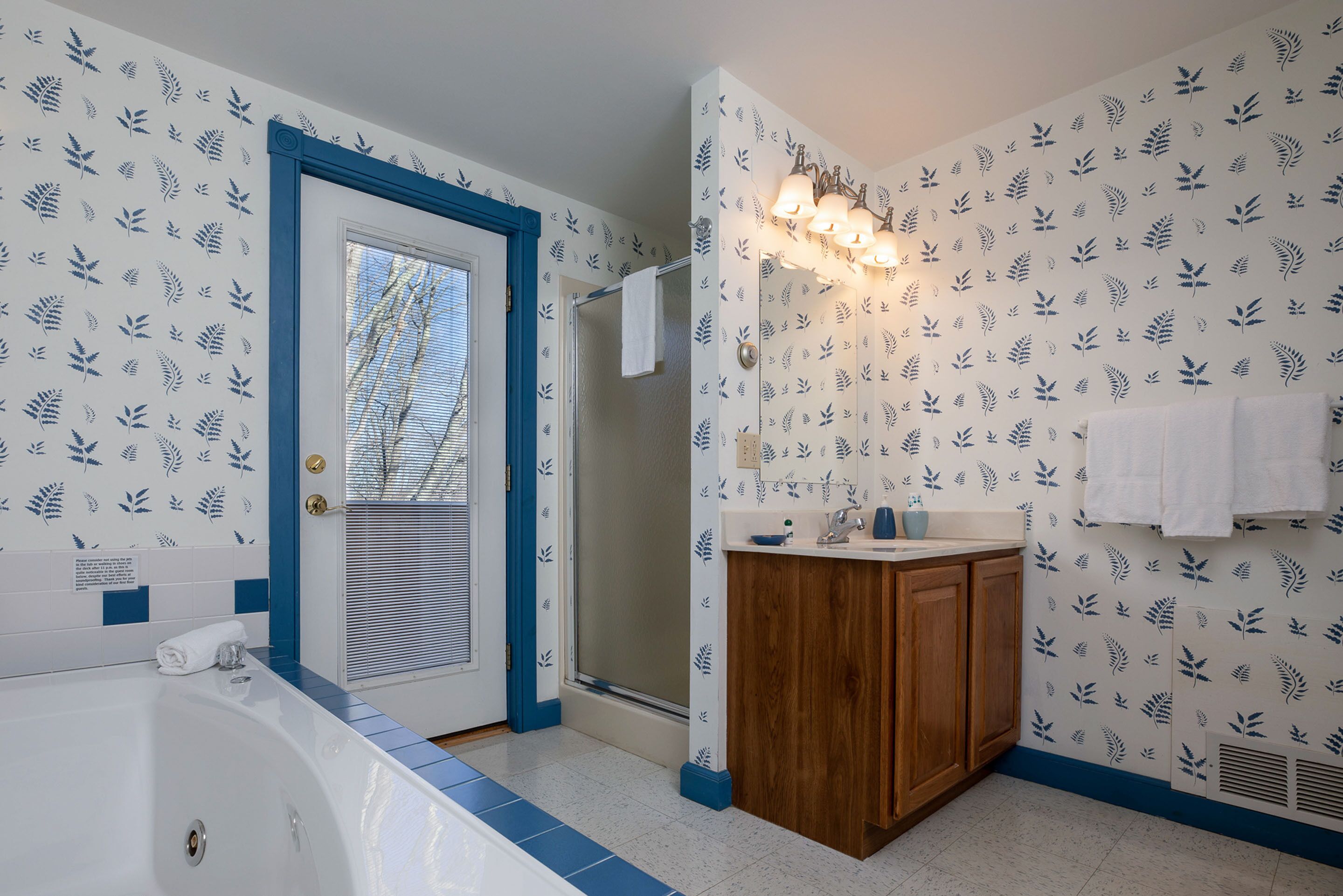Un baño con bañera, ducha y tocador de madera con lavabo.