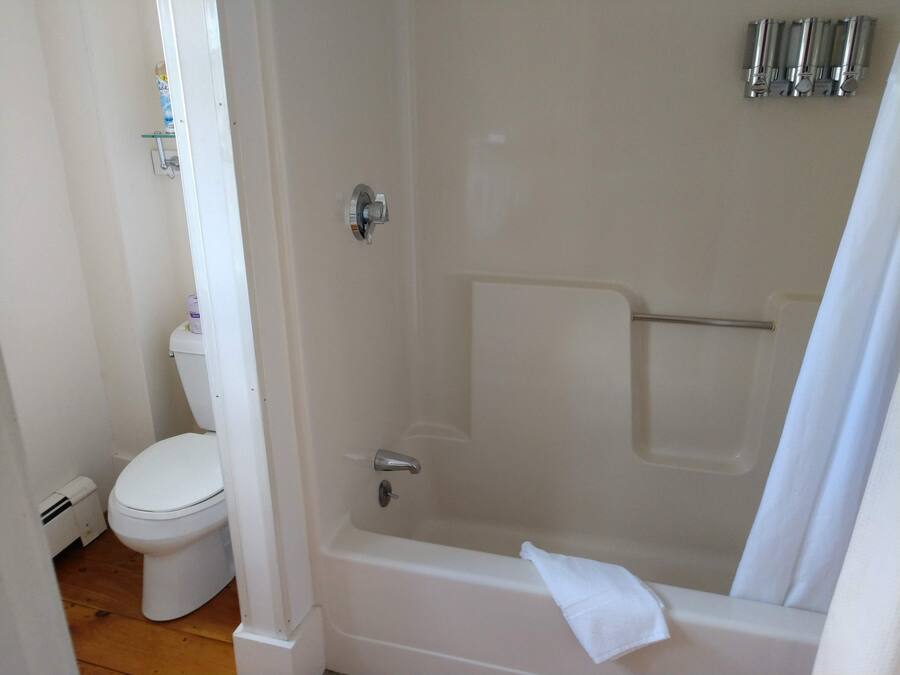 Ein Badezimmer mit Toilette, Badewanne und Duschbereich.