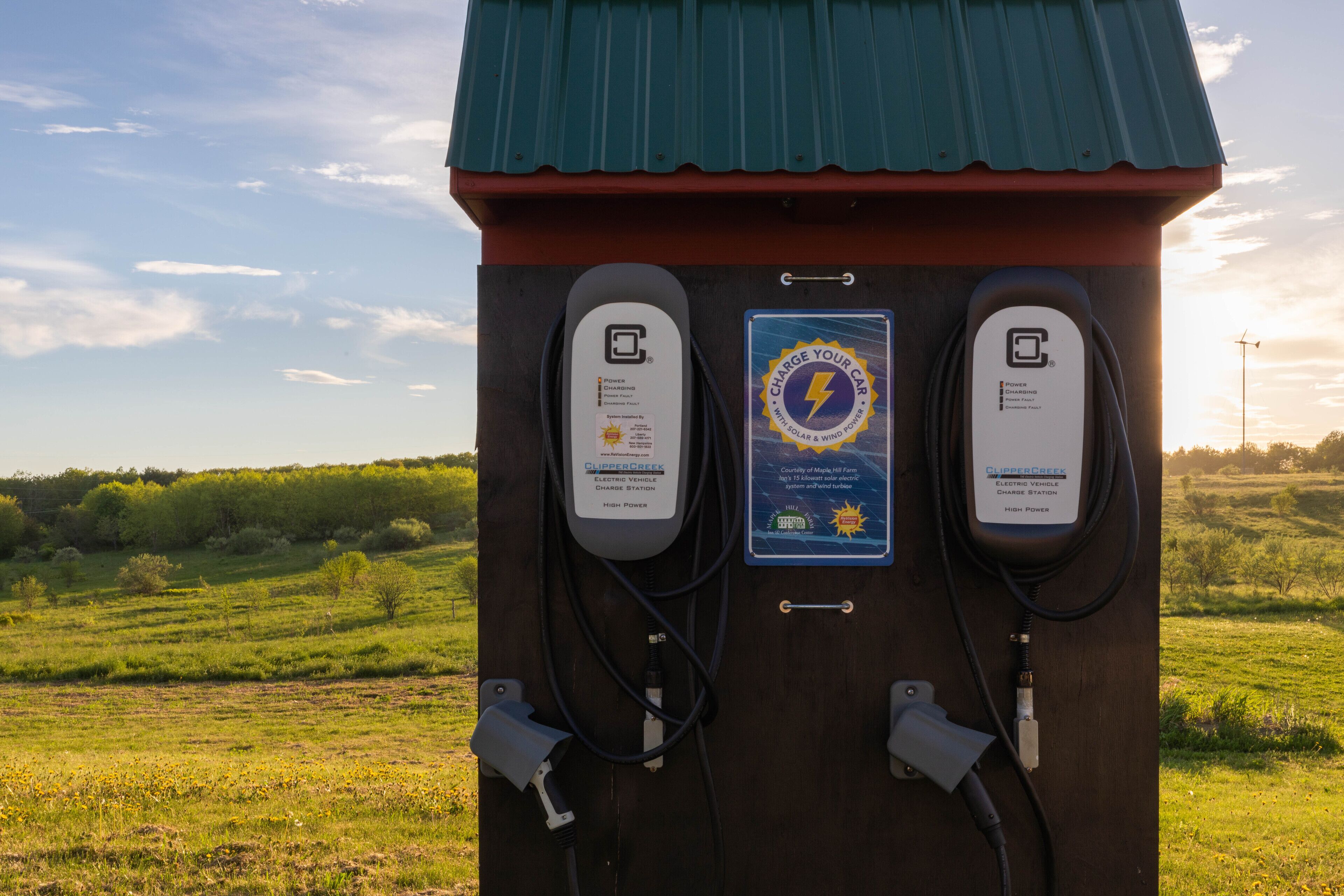 Een laadstation voor elektrische voertuigen, aangedreven door zonne-energie, met twee oplaadpunten, gelegen in een landelijke omgeving.