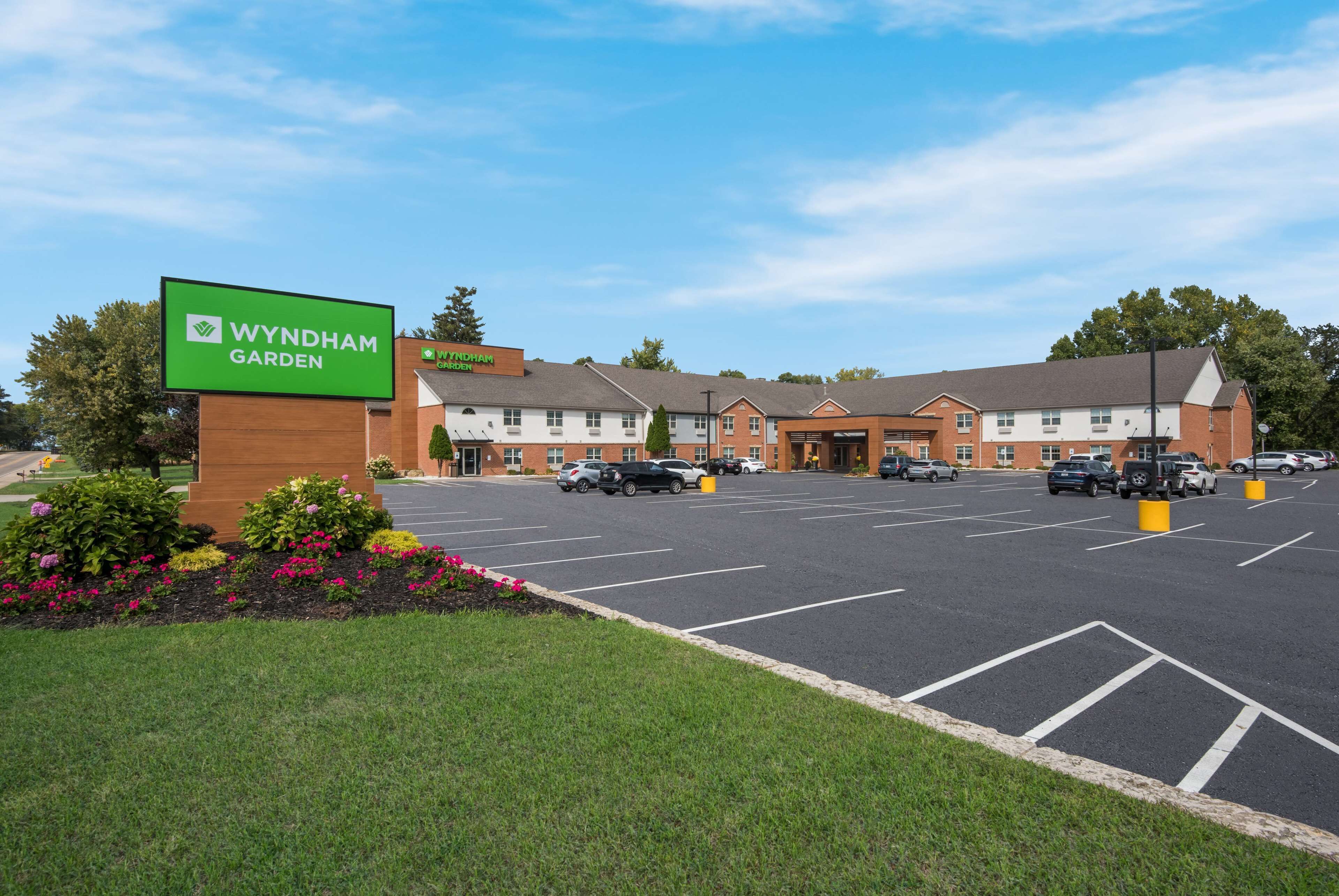 A Wyndham Garden hotel with a parking lot, multiple buildings, and a sign.