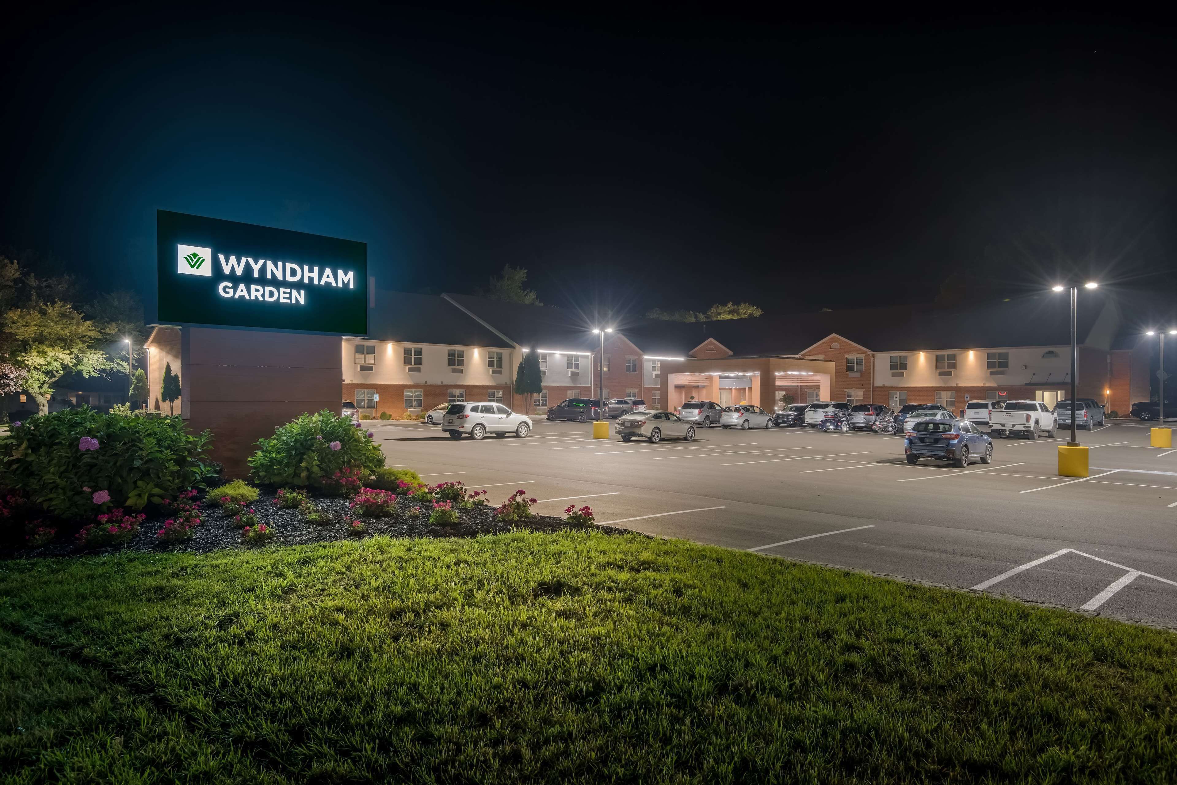 A Wyndham Garden hotel with a parking lot and well-lit exterior at night.