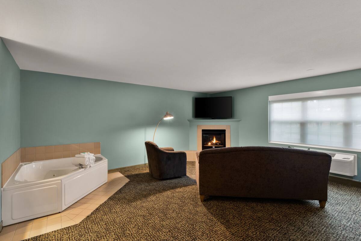 Un baño moderno con bañera, ducha y chimenea.
