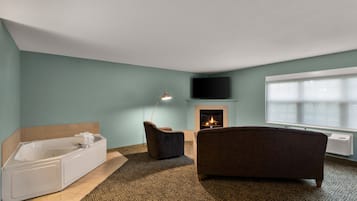 A modern bathroom with a bathtub, a shower, and a fireplace.