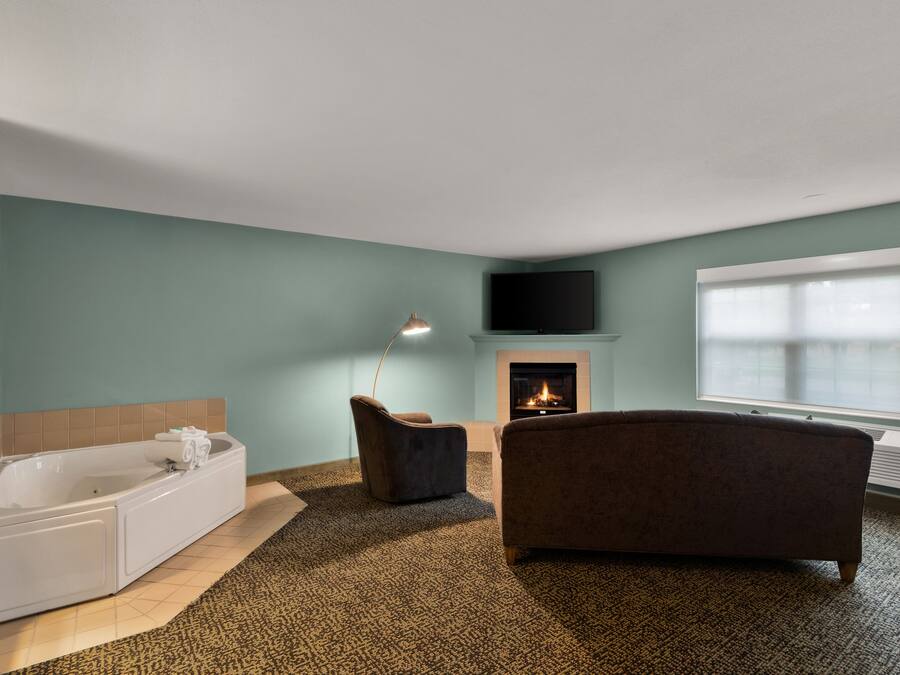 A modern bathroom with a bathtub, a shower, and a fireplace.