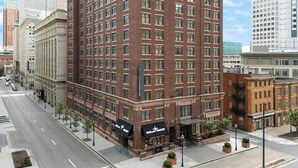 A multi-story building with a brick facade, large windows, and a corner entrance with a sign. - Residence Inn by Marriott Baltimore Inner Harbor (Baltimore)