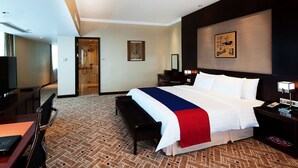 A hotel room with a large bed, a desk, a chair, a TV, and a bathroom. - Crowne Plaza Shanghai Pudong by IHG (Shanghai)