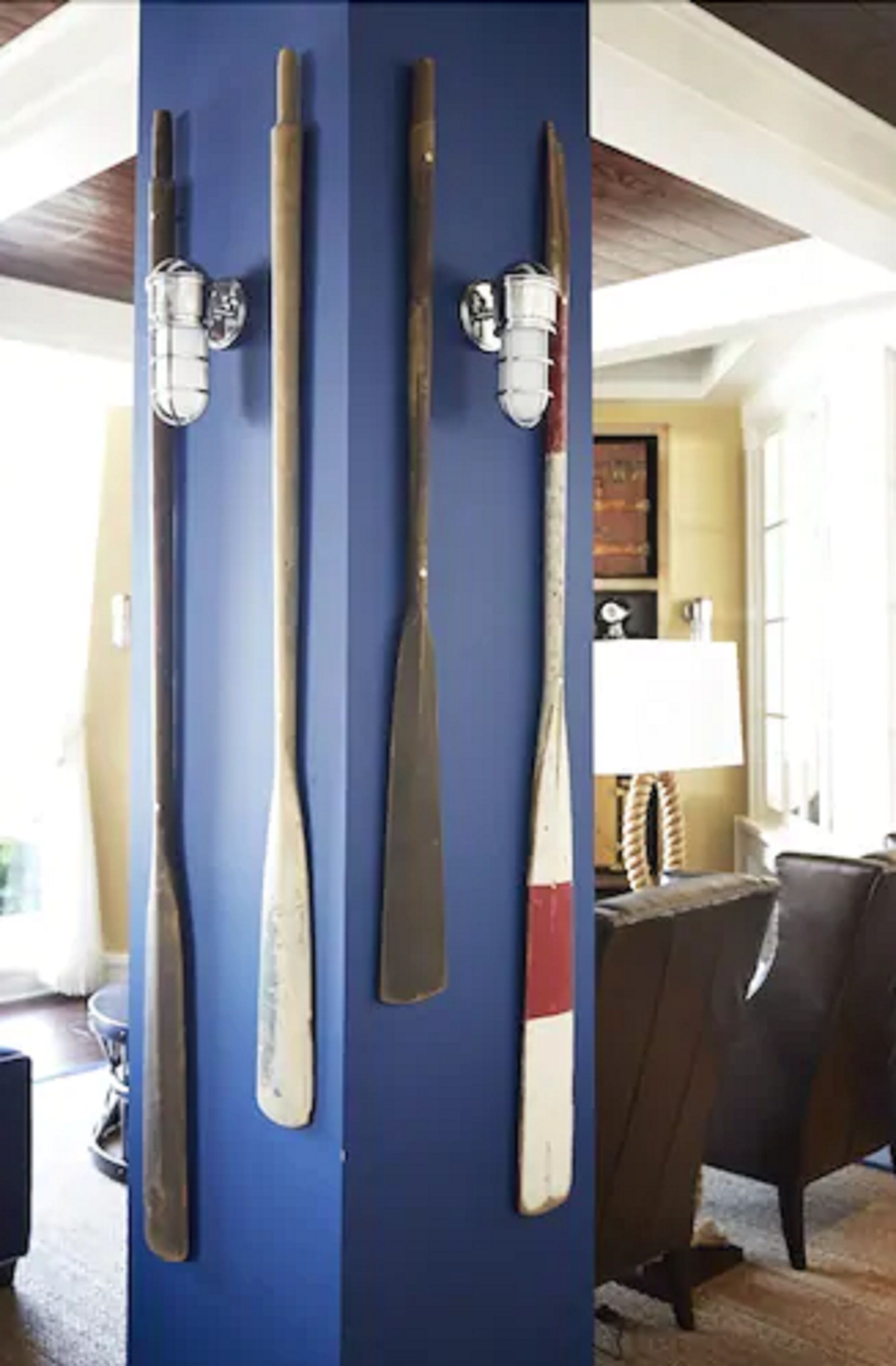 A blue wall with four wooden paddles mounted on it.