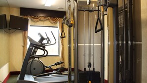 A gym with exercise equipment including a treadmill, weight machines, and a cable machine. - Red Roof Inn & Suites Detroit-Melvindale/ Dearborn (Melvindale)
