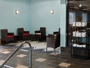 A room with a checkered floor, a reception desk, and a shelf with folded towels. - Red Roof Inn & Suites Detroit-Melvindale/ Dearborn (Melvindale)