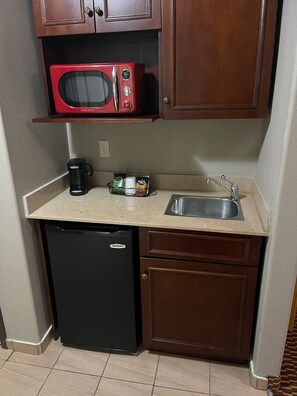 A compact kitchen with a microwave, coffee maker, and a sink. - Red Roof Inn & Suites Detroit-Melvindale/ Dearborn (Melvindale)