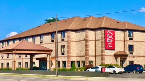 Ett Red Roof Inn-hotell med en fasad av tegel, flera fönster och en överbyggd entré.