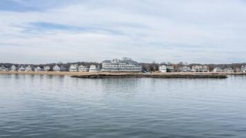 A waterfront property with a large building, a dock, and a row of houses along the shore.