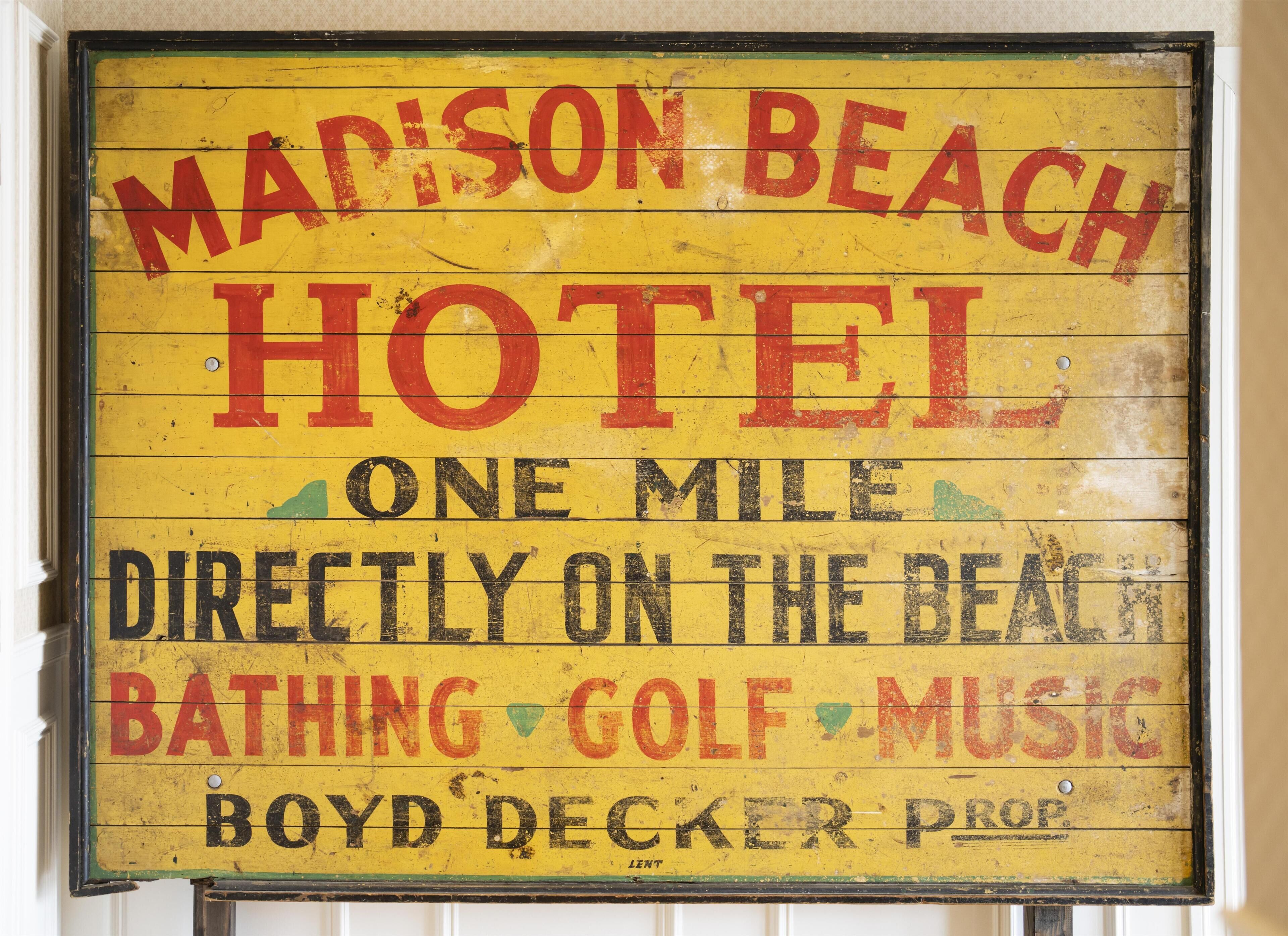 Cartel antiguo del 'Mapison Beach Hotel' que enumera los servicios: baño, golf, música, Propiedad de Boyd Decker.