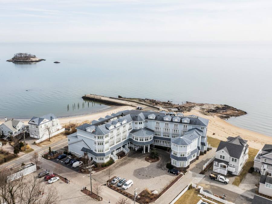 A large waterfront property with multiple buildings, a dock, and a beach.