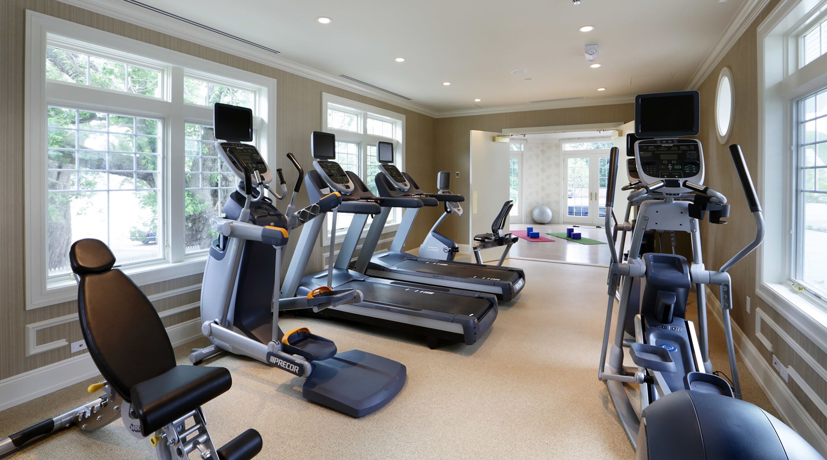A gym with treadmills, elliptical machines, and weight equipment.